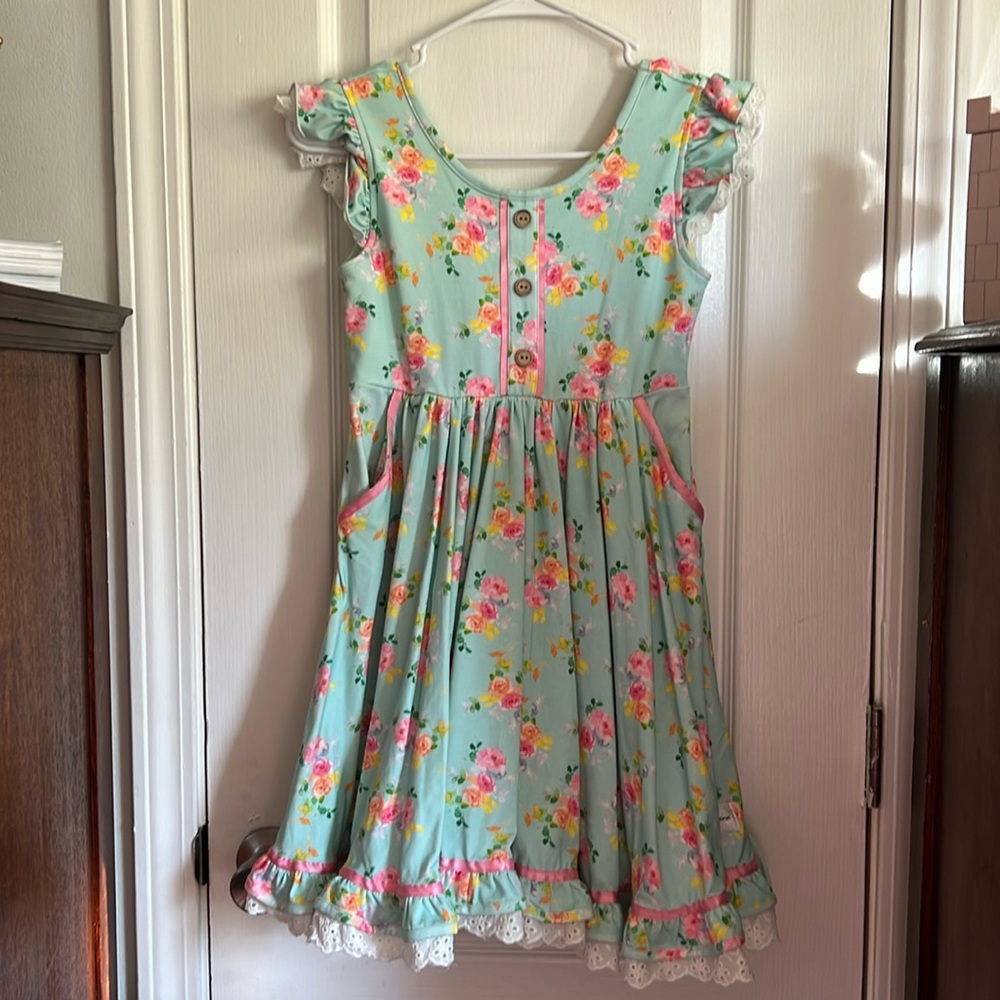blue dress, yellow, orange and pink white trimming brown buttons, pink ribbon
